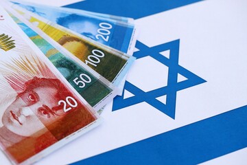 Israel New Shekels banknotes on national flag. The current Israel money bills lies on flag
