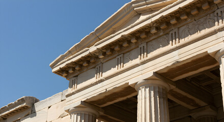 Naklejka premium Ancient temple facade with intricate stonework and classical columns under a clear sky.