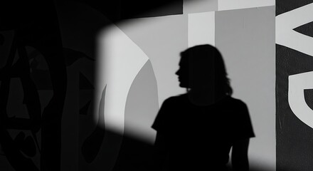 Silhouette Mystery: A mysterious silhouette of a person stands against an abstract wall in a dimly lit room. The dramatic lighting and stark contrast create a sense of intrigue and suspense.