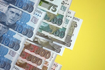 Pakistan rupees banknotes on yellow background. The current Pakistan money bills