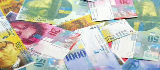 Swiss franc banknotes. The current francs money bills lies on table in big amount