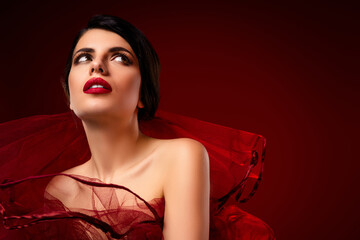 Tempting portrait of a glamorous young woman in red attire, showcasing sophisticated beauty,...