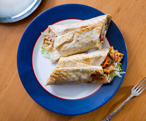 Delicious doner donair kebab wrap with meat, lettuce, tomato, red onion