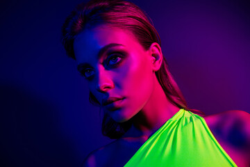 Portrait of a glamorous young woman illuminated by vibrant neon lights, showcasing modern beauty...