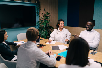 Confident Black businessman holding phone in relaxed setting, checking information or preparing for virtual call, highlighting mobile technology in modern professional environment