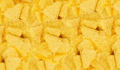 Heap of triangle corn chips pattern, food textured background