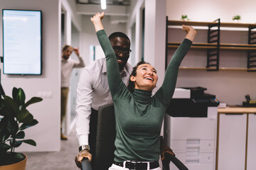Coworkers smiling and interacting during team talk in shared office space, relaxed and...