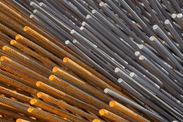 Rusty, gray ribbed steel bars forming a captivating texture, highlighting the interplay of oxidized...