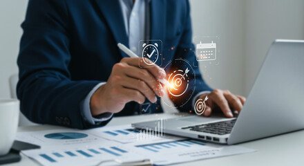 Business Analytics and Data Analysis: An executive works diligently on a laptop, surrounded by charts and documents.