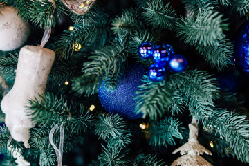 Bright blue ornaments and stockings adorn a festive Christmas tree in a cozy setting