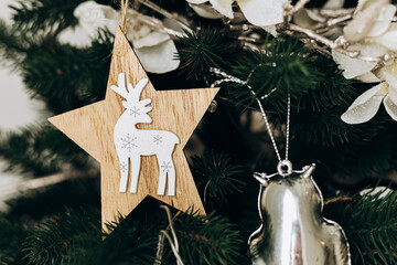 Decorative wooden star ornament featuring reindeer hanging on a Christmas tree