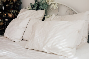 Cozy bedroom with white pillows and festive decorations during the holiday season