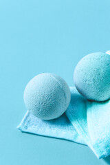 Bright blue bath bombs resting on a soft towel against a turquoise background