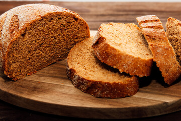 Freshly baked brown bread slices arranged neatly on a wooden board