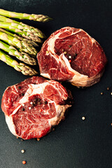 Freshly cut beef steaks with green asparagus ready for cooking in a kitchen setting