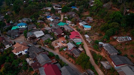 Colorful roofed traditional homes clustering mountain village landscape, surrounded by verdant...