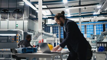 Executive consultant oversees solar energy systems in industrial workplace, emphasizing strategic...