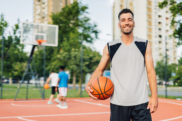 Basketball player smiling on court holding ball