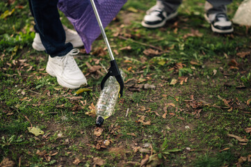Volunteers picking up plastic bottle trash in park cleanup event