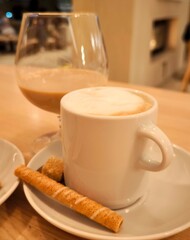 A cozy coffee moment: cappuccino with cookies and liqueur in a glass