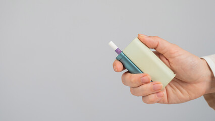 Woman holding electronic cigarette on white background. Tobacco heating systems.