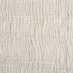 Cream wrinkled muslin fabric close-up, organic cotton texture, natural crumpled textile background, soft airy material