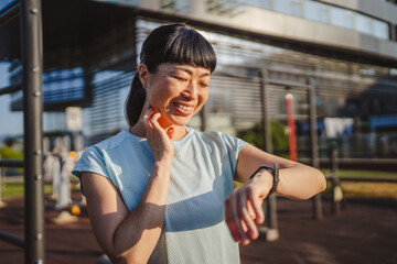 mature japanese sportswoman check her performance data on smart watch