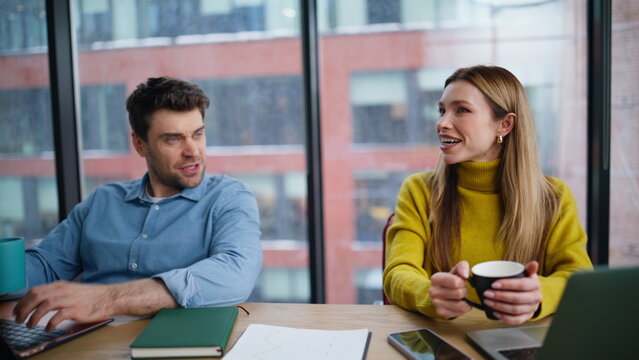 Friendly coworkers talking office closeup. Smiling woman man holding coffee cups