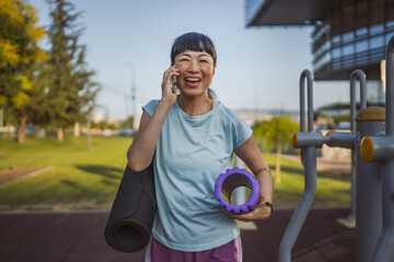 Portrait of mature japanese sportswoman hold equipment and cellphone
