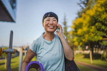 Portrait of mature japanese sportswoman hold equipment and cellphone