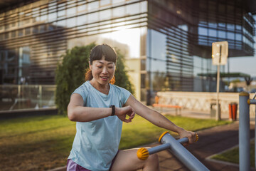 japanese woman exercise on an stationary bike in outdoor gym