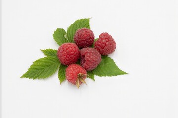 Ripe red raspberries with leaves on white background, macro close-up composition
