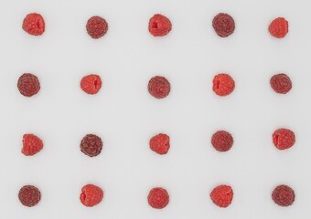 Ripe Raspberries with Green Leaves in Symmetric Composition on White Background