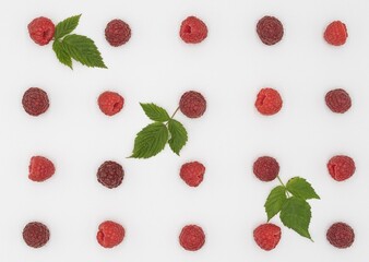 Ripe Raspberries with Green Leaves in Symmetric Composition on White Background