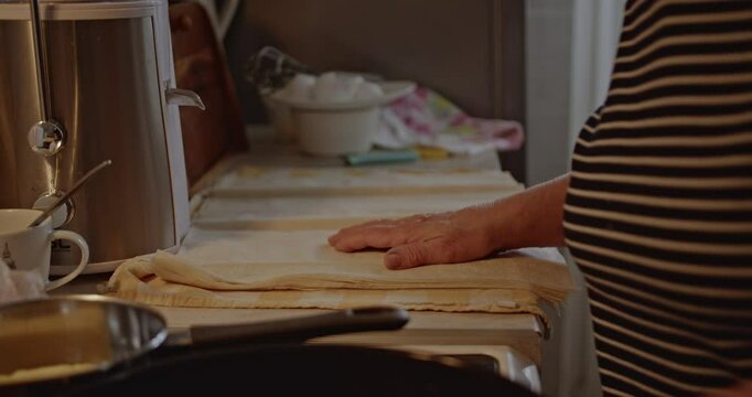 Senior woman greasing a baking pan in her kitchen. She is preparing to bake.