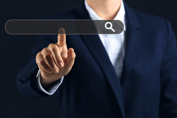Businesswoman using virtual screen on dark background, closeup
