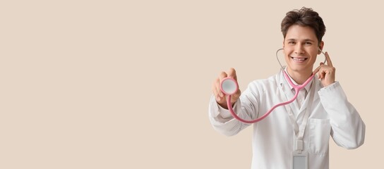 Male medical student with stethoscope on beige background with space for text