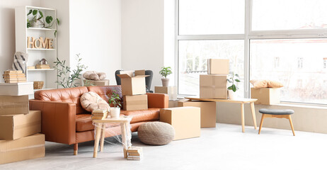 Sofa with table and cardboard boxes in living room on moving day