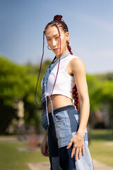 Woman with braids and distinctive denim outdoors