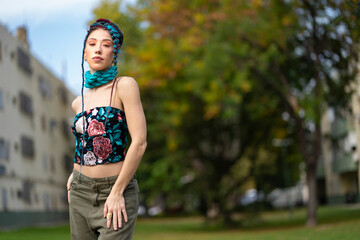Woman with colorful braids and embroidered top in a city setting