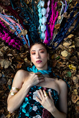 Woman with unique hair lying amongst dry leaves