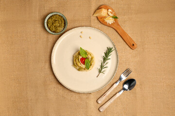 Plate with tasty pesto pasta with tomato on table