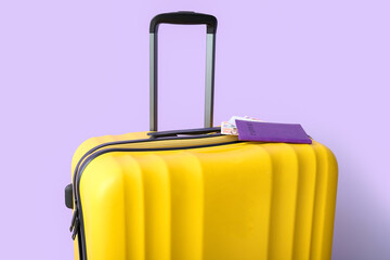 Suitcase with passport, ticket and money on lilac background. Travel concept