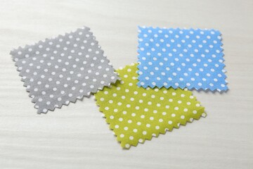 Fototapeta premium Samples of different fabrics on white wooden table, closeup