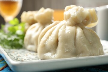 Delicious cooked khinkali served on table, closeup