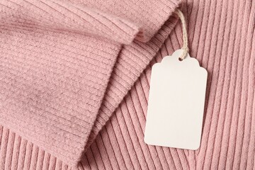 Cardboard tag on pink garment, top view