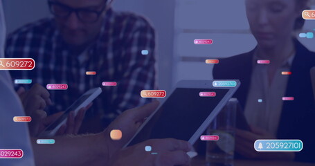 Business professionals discussing analytics on tablets in conference room, with notification icons