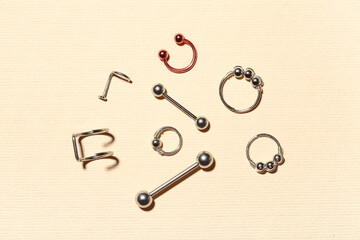 Set of stylish jewelry for piercing on color background