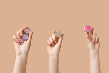 Female hands with glitters on beige background