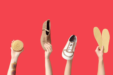 Female hands with shoes, insoles and brush on red background. Shoe repair concept